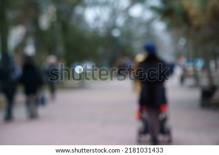 Blurred background. People are walking in the city park. City life. Background image.
