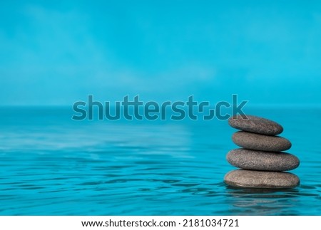 Zen stones in the blue water, copy space for text. Conceptual image.