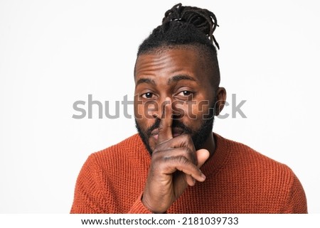 African-american young man showing silent gesture, finger on lips, top secret, telling rumors gossip isolated in white background Royalty-Free Stock Photo #2181039733