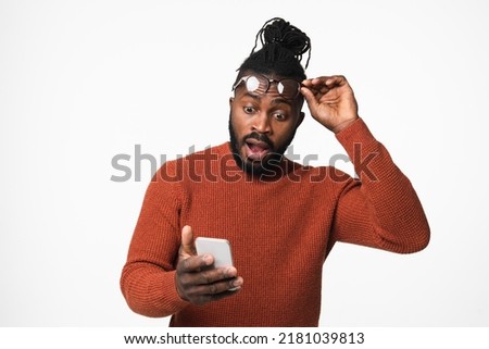 Cropped image of shocked impressed african-american young man winning money on bet in online casino, reading news on cellphone smart phone isolated in white background Royalty-Free Stock Photo #2181039813