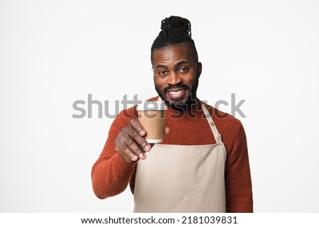 African-american young man barman barista bartender in apron selling giving making coffee cup hot beverage drink for take away isolated in white background