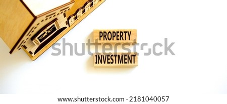 Property investment symbol. Concept words Property investment on wooden blocks on a beautiful white table white background. Wooden house model. Business Property investment concept. Copy space.