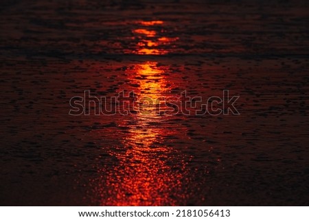 Beautiful blazing sunset landscape at orange sea and sky above it with awesome sun golden reflection on sea as a background. Amazing summer sunset view on the beach. Asturias, Spain.