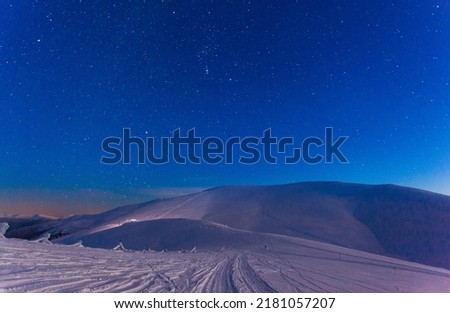 Fantastic starry sky. Winter landscape and snow-capped peaks. Carpathian mountains. Ukraine. Europe.
