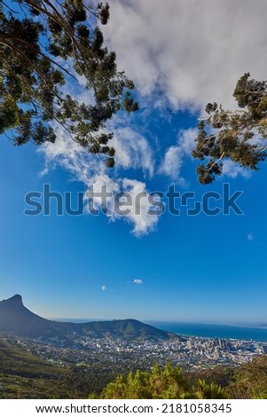 Beautiful view of a cityscape, nature and Table Mountain in Cape Town, South Africa against a cloudy blue sky with copy space. Landscape of a popular tourist town with greenery during summer