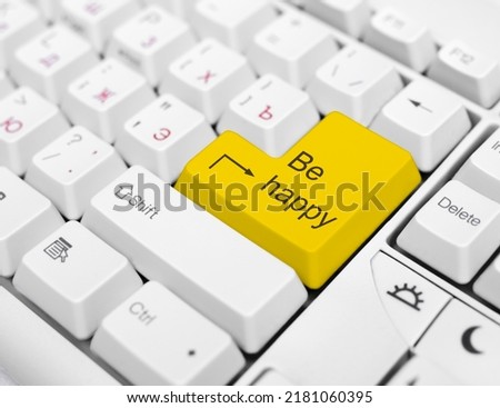 Yellow key with "be happy" lettering on the keyboard, the concept of becoming a happy person