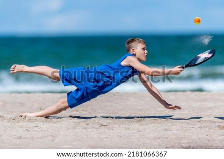 Young boy playing tennis on beach. Kids sport concept. Horizontal sport theme poster, greeting cards, headers, website and app