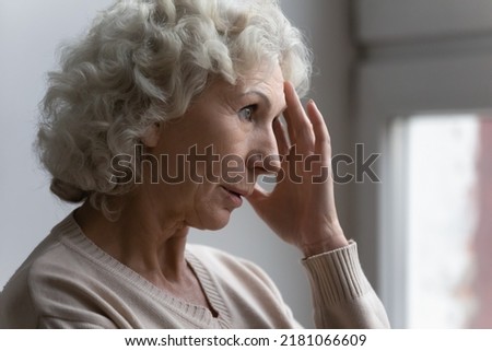 Confused worried old lady suffering from age disorders, Alzheimer disease, headache. Concerned pensive senior 70s woman feeling anxiety, losing memory, having mental disease symptoms. Close up Royalty-Free Stock Photo #2181066609