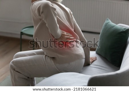 Mature senior lady feeling muscles pain attack, holding back, having problem with standing up. Elderly woman suffering from chronic backache, kidney disease, lumbar osteochondrosis, inflammation Royalty-Free Stock Photo #2181066621