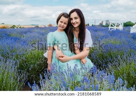 Nature, blue sky, family rest. Mother and daughter spend their weekend happily.mother enjoying time with little child daughter girl, gently touching sniffing aromatic flowers in lavender.
