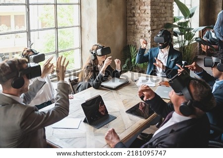 Group of businessperson brainstorming on a virtual project wearing 360 3d vr goggles and sitting around the table - people meets in metaverse reality - business lifestyle concept Royalty-Free Stock Photo #2181095747