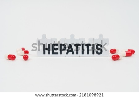 Medical concept. On a white surface are tablets and puzzles with the inscription - HEPATITIS