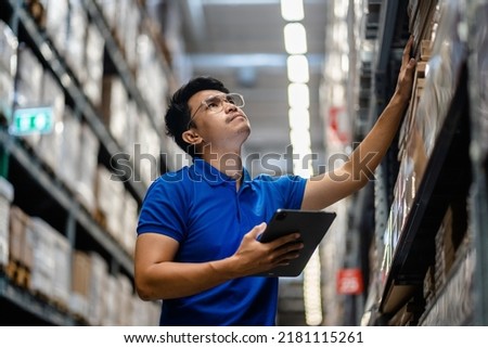 Warehouse Worker using digital tablets to check the stock inventory in large warehouses, a Smart warehouse management system, supply chain and logistic network technology concept. Royalty-Free Stock Photo #2181115261