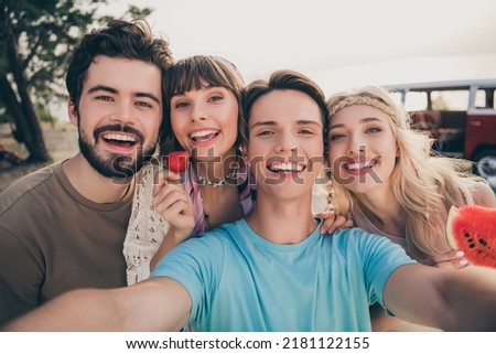 Portrait of positive hippie fellows enjoy seaside weekend make selfie hold berry water melon outside Royalty-Free Stock Photo #2181122155