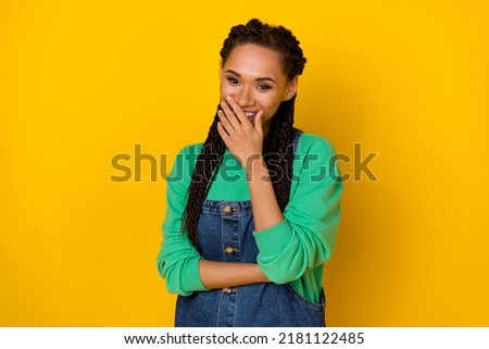 Photo of cheerful adorable person hand cover close mouth laughing isolated on yellow color background