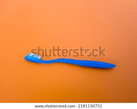 Blue toothbrush on orange background
