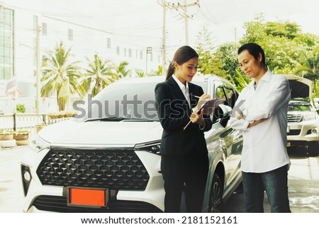 Businesswoman representing an auto insurance company enters into an insurance contract with the owner new car with a red license plate, and new driver to get life insurance for safety while traveling. Royalty-Free Stock Photo #2181152161