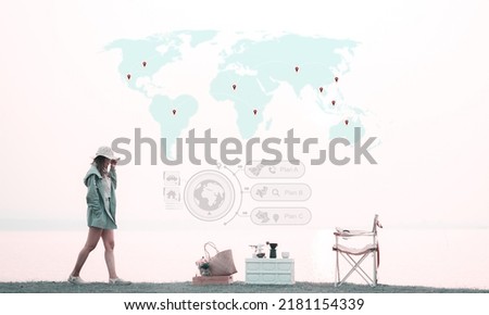 Asian traveling woman walking on the grass near the lake in morning, Tourists dreaming about adventure map of the world painted in the sky, plan to travel around the world, selective and soft focus. Royalty-Free Stock Photo #2181154339
