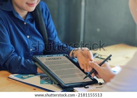 Hand of a young businesswoman persuading his clients to sign a contract. using a tablet to make a contract	
