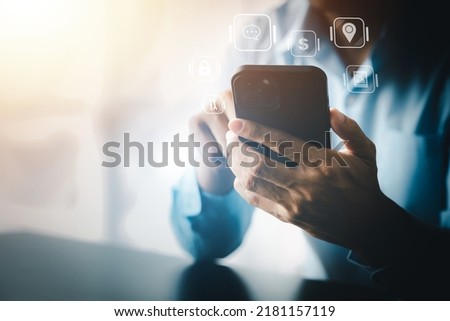 A person holding a smartphone and holographic graphics icon to use it, surfing the Internet on a smartphone device, using technology to communicate and facilitate and entertain.