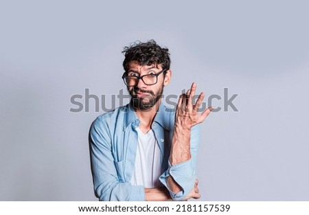 Puzzled man gesturing with one hand, Person with puzzled face frowning, Close up of puzzled people gesturing with hands. Royalty-Free Stock Photo #2181157539