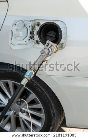 White car at a gas station. The process of refueling a car with liquefied gas Royalty-Free Stock Photo #2181191083