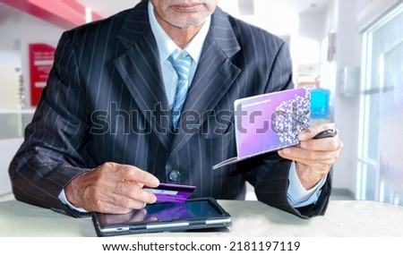Businessman hand holding a plastic credit card and bank book