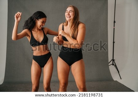 Two diverse women in their black underwear having fun in the studio Royalty-Free Stock Photo #2181198731