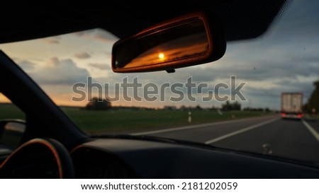 Sunset in a rear-view mirror, travelling Europe Royalty-Free Stock Photo #2181202059