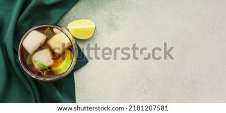 Glass of tasty Cuba Libre cocktail on light background with space for text, top view