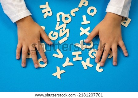The child lays out the letters on the table. The concept of the school of education