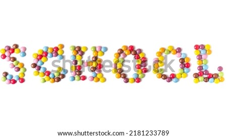 Isolated word SCHOOL. Multi-colored round candies on white backgrounds.