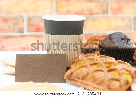 Business card template with paper cup and assorted pastries