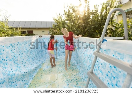 Shot of a mother and daughter cleaning the pool together