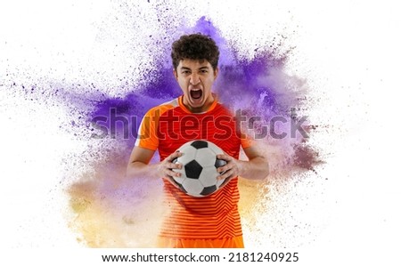 Creative sport collage with young professional soccer player setting to win isolated on white background with colorful powder splash. Victory, energy, sport and betting. Bright emotions. Flyer for ad Royalty-Free Stock Photo #2181240925