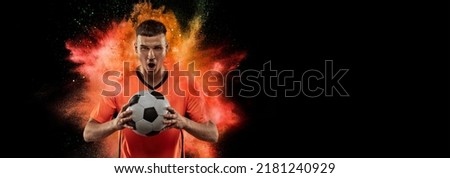 Creative sport collage with young man, professional soccer player setting to win isolated on black background with powder splash. Victory, energy, sport and betting. Bright emotions. Flyer for ad