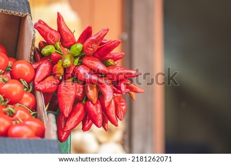 Bunch of red hot chili peppers hanging in a street food market, close up Royalty-Free Stock Photo #2181262071
