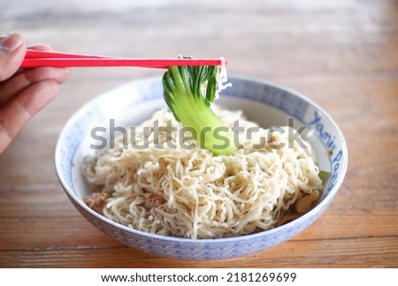 One portion yamie or noodle on the table or satu mangkuk yamie panda, mie keriting kecil, lembut dan halus. rasanya enak dan nikmat toping sayur, ayam giling, pangsit dan acar