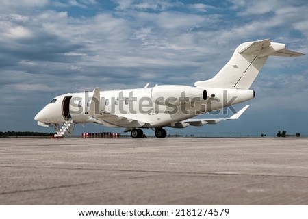 Modern white private jet with an opened gangway door at the airport apron Royalty-Free Stock Photo #2181274579