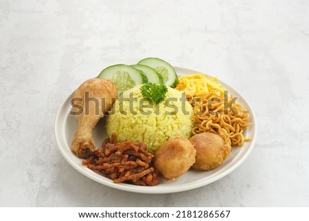Nasi kuning, Indonesian traditional food, made from rice cooked with turmeric and coconut milk and spices.
 Royalty-Free Stock Photo #2181286567