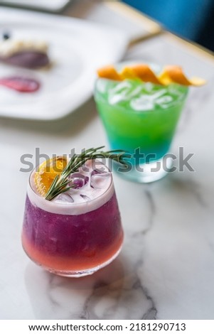 lychee and butterfly pea mock-tail with orange and rosemary garnish Royalty-Free Stock Photo #2181290713