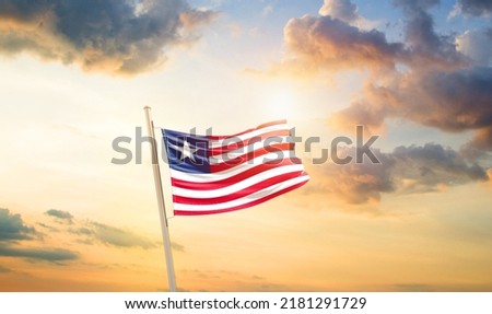 Liberia national flag waving in beautiful clouds.