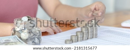 Young woman puts the coins on the money step or on the pile of money to keep for future use, Money management for use when needed, Saving money for future growth.