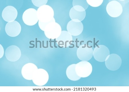 Blue Defocused Bright abstract winter background with white shimmering sunspots. Bokeh. Holiday festive concept. Copy space for text. Merry Christmas and Happy New Year