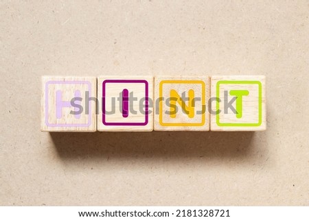 Color letter block in word hint on wood background
