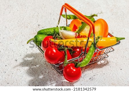 Sale concept. Different vegetables in a basket. Summer harvest, modern hard light, dark shadow. Healthy dieting food, light putty background, close up