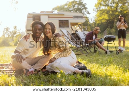 A couple in love spend time together with friends traveling in a camper van.