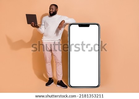 Full body photo of masculine guy use netbook search gadget eshop stand panel menu isolated on pastel color background