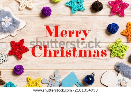 Merry Christmas text. Top view of Christmas decorations and toys on wooden background. Copy space. Empty place for your design. New Year concept.