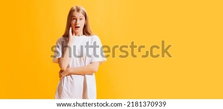 Wow, surprise. One young beautiful girl, student in casual style outfit isolated on bright yellow background. Concept of beauty, art, fashion, youth, healthy lifestyle. Copyspace for ads, text
